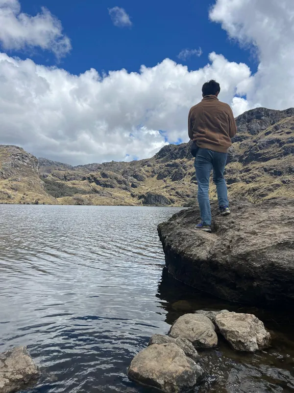 A traveler above a glacial lake in El Cajas National Park